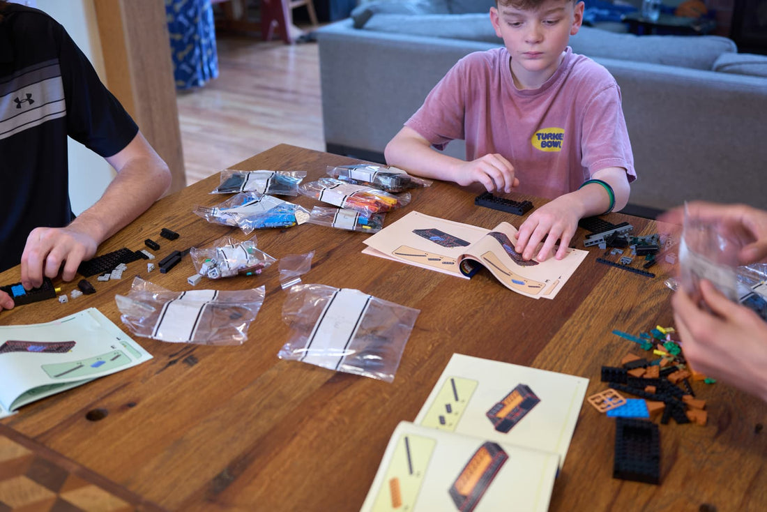 Kids building Bible Bricks at the kitchen table with instruction booklets